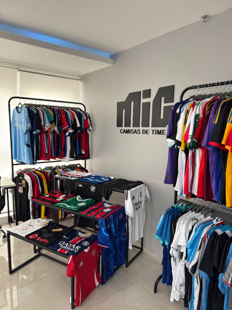Interior da loja MIC Camisas de Time com araras e mesas de camisas expostas